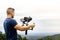 Young caucasian man handling a camera on top of a gimbal while working on recording a scene