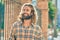 Young caucasian man with long hair smiling happy at the city