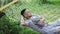 Young caucasian man lying down and swinging in hammock in pleasant laziness of weekend morning. Man Relaxing in hammock in summer