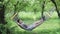 Young caucasian man lying down and swinging in hammock in pleasant laziness of weekend morning. Man Relaxing in hammock in summer