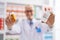 Young caucasian man pharmacist holding pills bottles at pharmacy