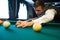 Young caucasian man playing billiards ready to shoot.