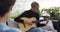 Young Caucasian man playing guitar on a rooftop