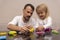 Young caucasian man plays with daughter making colorful animals from playdough