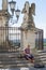 Young Caucasian man plays hang drum on the stairs to an angel statue in Avignon, France
