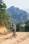Young Caucasian man riding a mountain bicycle uphill in Muang Ngoi village, Laos