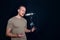 Young caucasian man singing in front of black soundproofing walls. Musicians producing music in professional recording studio