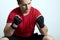 Young caucasian man in sportswear and boxing bandages sits with clenched fists, eyes are closed. Praying or despair moment, sorrow