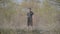 Young Caucasian man standing with fishing rod in spring forest. Wide shot portrait of fisherman waiting for fish to