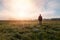 Young caucasian man standing, walking on meadow in misty fog at sunrise. Czech summer landscape