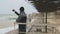 Young caucasian man taking photos on smartphone of sea at storm