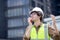 Young caucasian man using radio conversation and inspecting while building and tower all around.