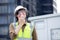 Young caucasian man using radio conversation and inspecting while building and tower all around, engineer or architect examining