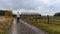 Young caucasian man walking on foothpath near stackade farm in rural czech landscape