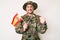 Young caucasian man wearing camouflage army uniform holding spanish flag annoyed and frustrated shouting with anger, yelling crazy