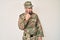 Young caucasian man wearing camouflage army uniform pointing to the eye watching you gesture, suspicious expression