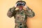 Young caucasian man wearing camouflage army uniform using binoculars smiling and laughing hard out loud because funny crazy joke