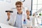 Young caucasian man wearing dentist uniform holding whitening and invisible aligner at clinic