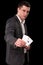 Young caucasian man wearing suit holding two aces in his hand on black background. Gambling concept. Casino