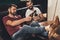 young caucasian men sitting on couch and drinking beer beside billiard table