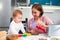 A young caucasian mother makes cookies with her baby and shows a cookie cutter. Close-up portrait. Kitchen in the