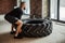 Young caucasian muscular man flipping heavy tire in gym