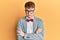 Young caucasian nerd man wearing glasses wearing hipster elegant look with bowtie skeptic and nervous, disapproving expression on