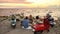 Young caucasian people, motorcycle riders enjoying the view while having picnic on the beach at sunset