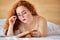 Young caucasian plus size model woman writes notes in her diary lying on bed