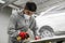 Young caucasian professional car service male worker with orbital polisher