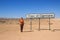 Young caucasian red-haired girl traveler backpacker on the background of a road sign Tropic of Capricorn in the Namib desert, Nami