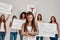 Young caucasian tattooed woman with dreadlocks having serious look. Group of diverse women holding protest banners for