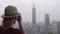 Young caucasian tourist taking photo of Taipei city in Taiwan from elephant mountain. Woman on vacation in asia. Female