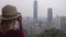 Young caucasian tourist taking photo of Taipei City in Taiwan from elephant mountain. Woman on vacation in asia. Female