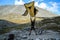 Young Caucasian white man tourist jumps and holds a tent in his hands raising it high above himself among the mountains