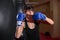 A young Caucasian woman actively trains in the gym and do boxing exercises in boxing gloves in front of a punching bag