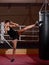 A young Caucasian woman actively trains in the gym and do boxing exercises in boxing gloves in front of a punching bag