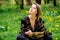 Young caucasian woman with book on meadow with dandelions.