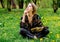 Young caucasian woman with book on meadow with dandelions.