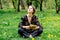 Young caucasian woman with book on meadow with dandelions.