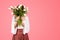 Young caucasian woman in casual covering face with bouquet of flowers, enjoy free time