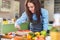 Young Caucasian woman cooking in the kitchen, making a cake, decorating it with strawberry