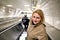 Young caucasian woman descends on an escalator to metro station