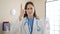 Young caucasian woman doctor saying no with finger at clinic
