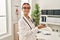 Young caucasian woman doctor smiling confident doing welcome gesture at clinic