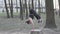 A young Caucasian woman does a handstand in a wooded area, leaning her hands on a stump tree. Healthy Lifestyle female