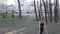 A young Caucasian woman does a handstand in a wooded area, leaning her hands on a stump tree. Healthy Lifestyle female