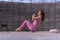 Young caucasian woman is exercising while sitting on a yoga block