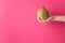 Young caucasian woman girl holds in stretched hand whole brown coconut on fuchsia pink wall background. Tropical fruits