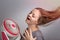 Young Caucasian woman girl with long hair holding electric fan in front her face. Cool down in hot summer weather concept